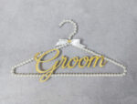 Κρεμάστρα με πέρλες, χρυσό καθρέφτη plexiglass με το "Groom" και σατέν κορδέλα.