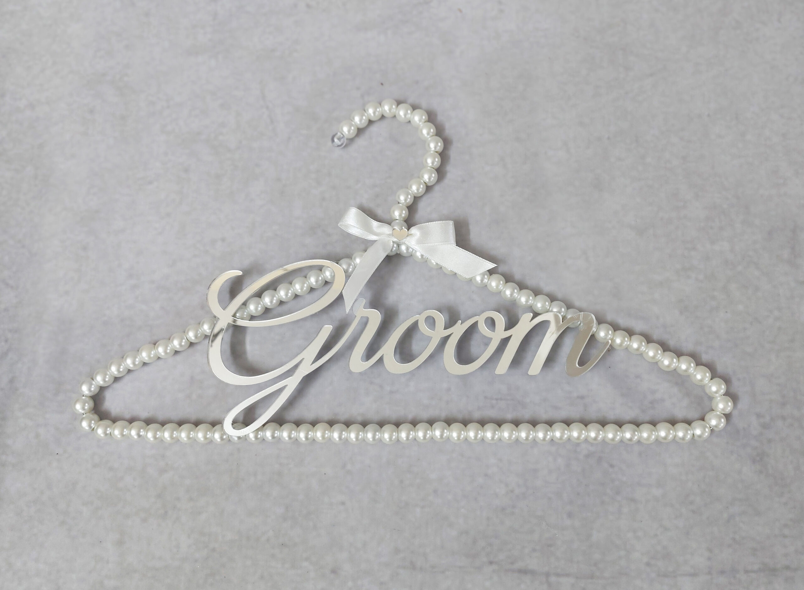 Κρεμάστρα με πέρλες, ασημί καθρέφτη plexiglass με το "Groom" και σατέν κορδέλα.